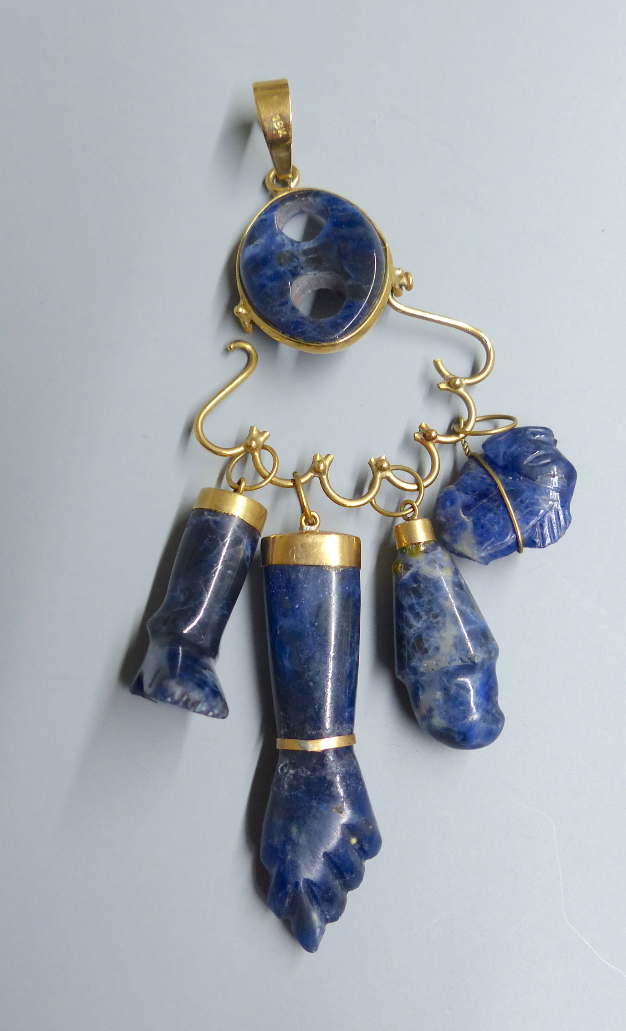 A continental 18k yellow metal and blue banded agate? set charm pendant, gross 25.6 grams, a similar pebble and an agate arm pendant